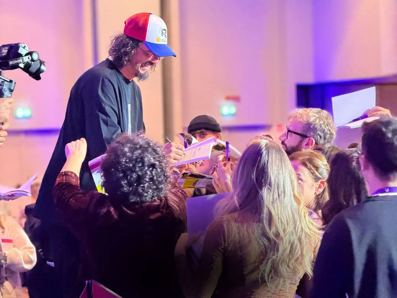 Luca Picchio con il cappellino rosso, bianco e blu firma i libri tra il pubblico del Live